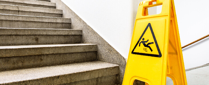 slip and fall sign at the bottom of stairs premises liability